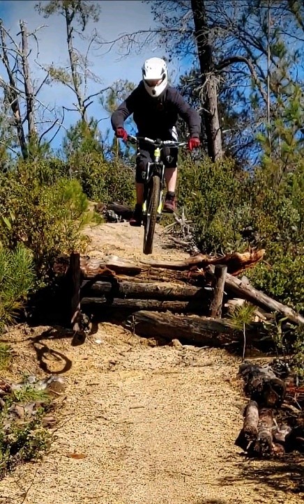 Jeff Druce jumping a mountain bike down a dirt hill
